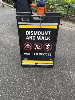 セントラルパークの看板は自転車を降りて歩くことを求めている（Dismount and work）