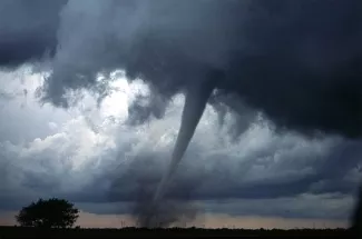 One of several tornadoes observed by the en:VORTEX-99 team on May 3, 1999, in central Oklahoma. Note the tube-like condensation funnel, attached to the rotating cloud base, surrounded by a translucent dust cloud.